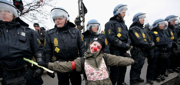 COP15 Reclaim power: A young demonstrator poses in front of a police line 