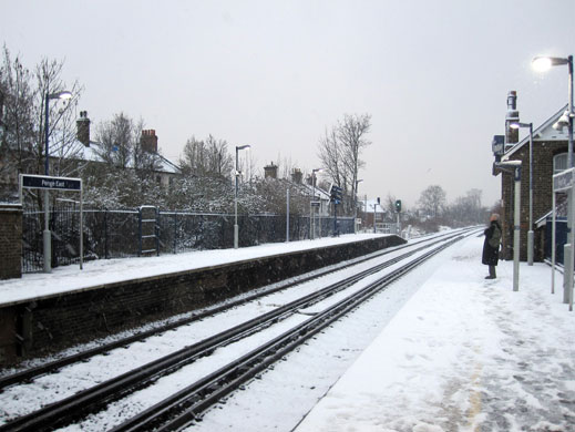 Snow in the UK: A lone commuter in the morning snow at Penge East Station, South London