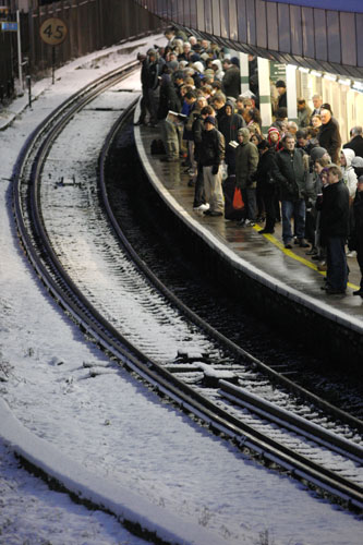 Snow in the UK: Commuters wait for a train at East Croydon railway station in south London