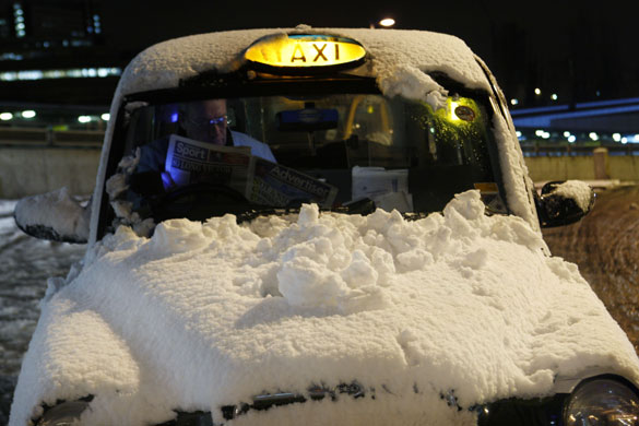 Snow in the UK: A snow covered taxi waits for a fare at East Croydon railway station