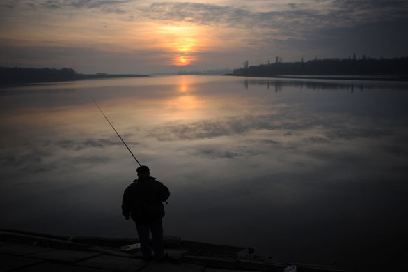 24 hours: Lake Pantelimon, Romania: An angler fishes at sunrise