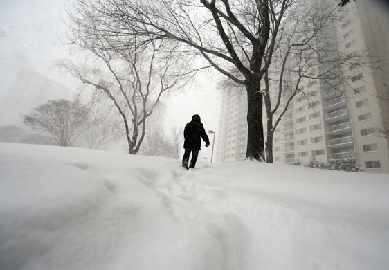 Snow around the world: A woman makes her way home under heavy snow fall in Maryland, US
