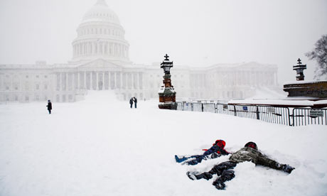 Children make snow angels in front of the US Capitol during near blizzard conditions.