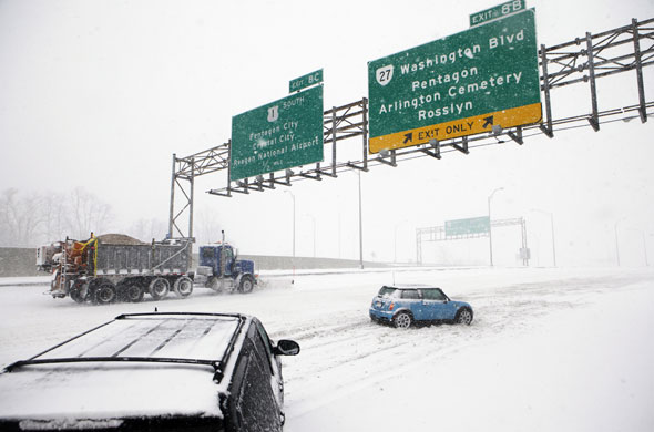 Snow around the world: Arlington, Virginia, US: A snow plough truck works to clear the road