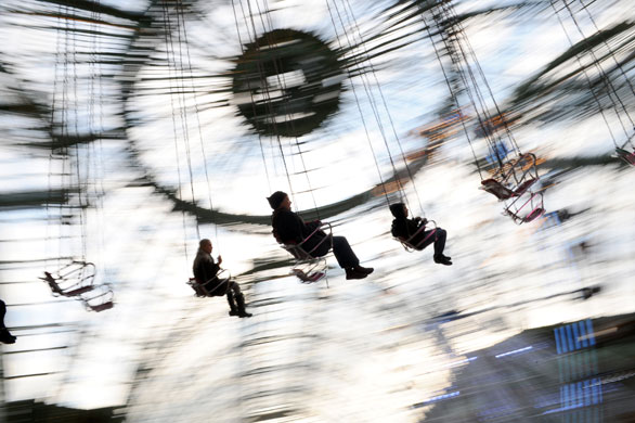 24 hours in pictures: Paris, France: People ride on a carousel at a funfair at the Grand Palais
