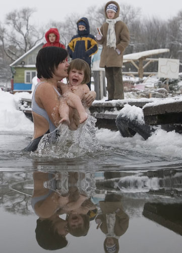 24 hours: A woman and her child prepare to dive into a lake in Minsk