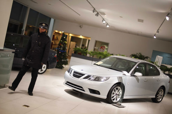 Saab cars: December 18, 2009: A security guard at aSaab dealership in Beijing