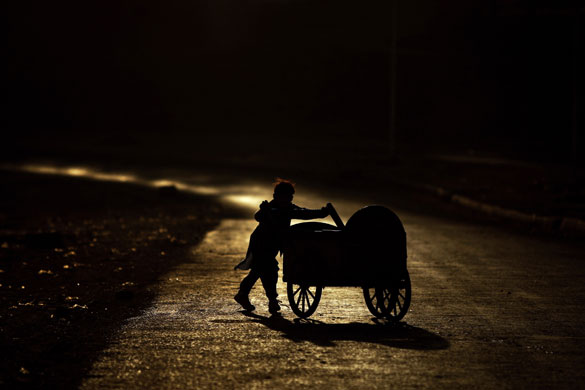 24 hours in pictures: Rawalpindi, Pakistan: A boy pushes a cart along the main street