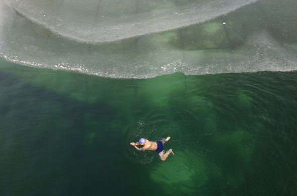 24 hours in pictures: Changzhi, China: A swimmer in a partially ice-covered pond