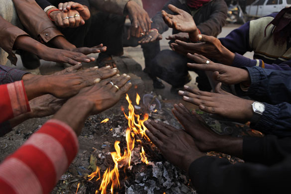 24 hours in pictures: Allahabad, India: People warm themselves around a  bonfire