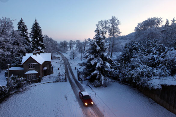 Travel chaos: A car negotiates a snowy lane in Luton