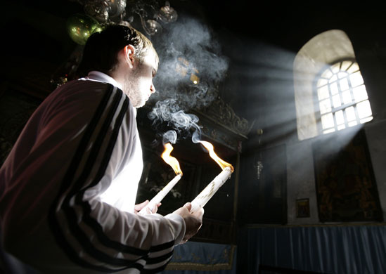 24 hours in pictures: Bethlehem, West Bank: A pilgrim holds candles in the Church of the Nativity