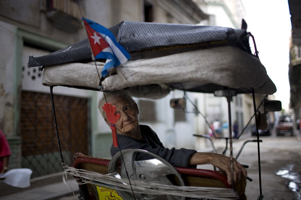 24 hours in pictures: Havana, Cuba: A woman sits on a bicycle