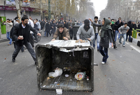 Iran: Opposition supporters push a rubbish container
