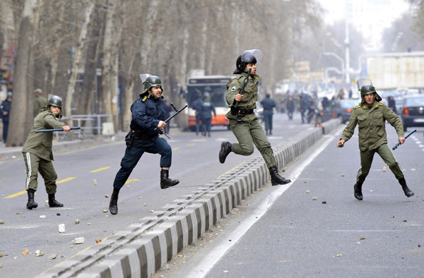 Iran: Riot policemen run after opposition supporters