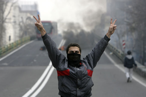 Iran protest updated: An Iranian protester, with his face covered, flashes victory signs
