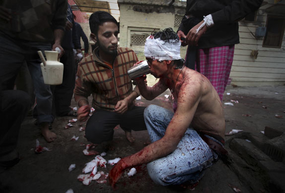 Ashura processions:  An Indian Shiite Muslim drinks water at a mosque on Ashura