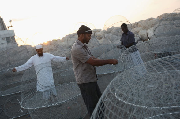 3 December 2009: Dubai, United Arab Emirates: Men work on traditional wire fishing baskets