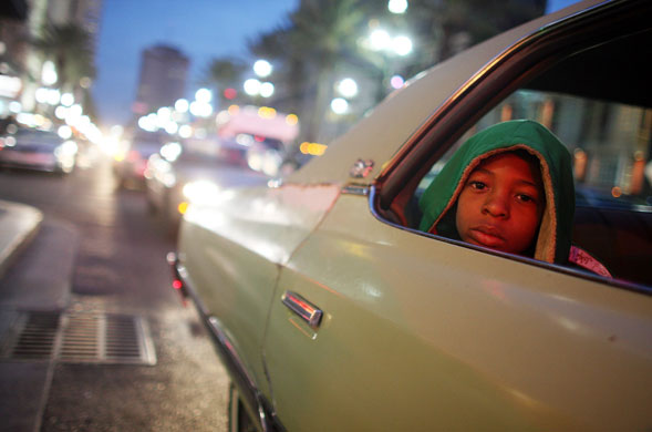 3 December 2009: New Orleans, US: A boy in a car on a street decorated with Christmas lights