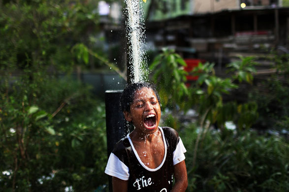 3 December 2009: Rio De Janeiro, Brazil: A child bathes under an outdoor shower