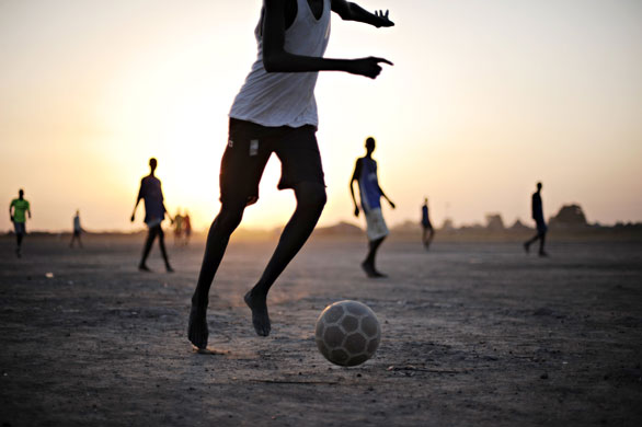 3 December 2009: Bentiu, Sudan: Boys play football on a dusty patch of land