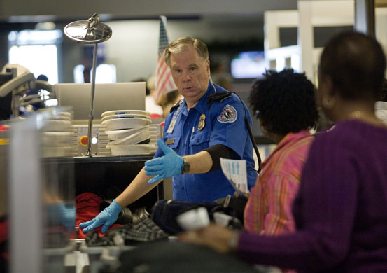Airport security: Texas, US: A TSA officer screens passengers at Dallas/Fort Worth Airport