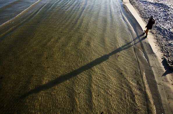 24 hours: Germany: A walker casts a long shadow along the beach