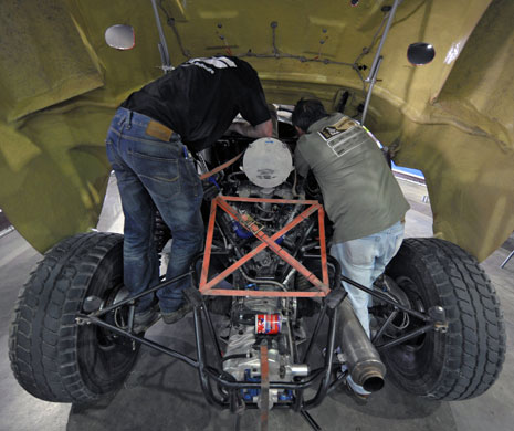 24sport: Two men check a car during technical verification of the Rally Dakar 2010