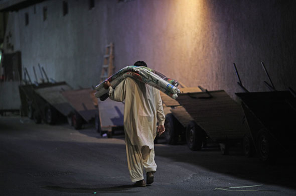 4 December 2009: Dubai, United Arab Emirates: A man carries rolls of material