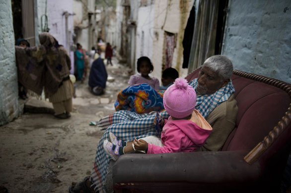 4 December 2009: Islamabad, Pakistan: A girl sits with an elderly man on a sofa