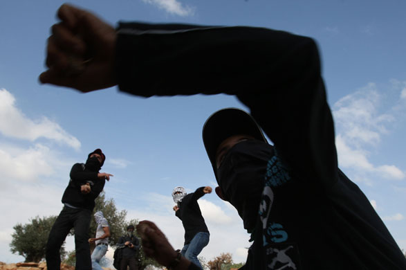 24 Hours: Palestinian protesters hurl stones at Israeli soldiers during a protest