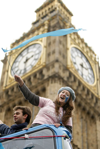 Wave climate change demo: A demonstrator waves a blue flag near Big Ben during a climate change march