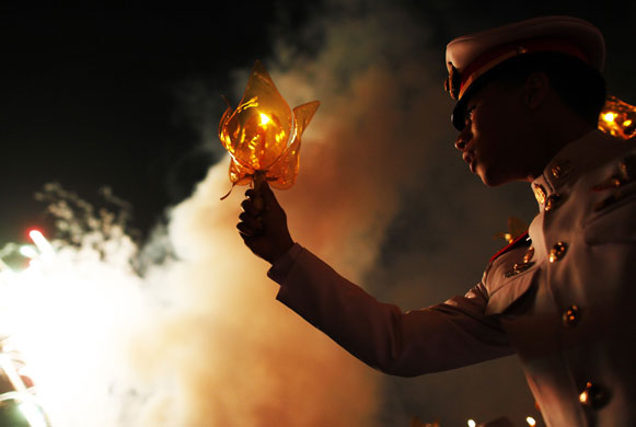 24 hours: Bangkok, Thailand: Wellwishers hold candles for the Thai king's birthday