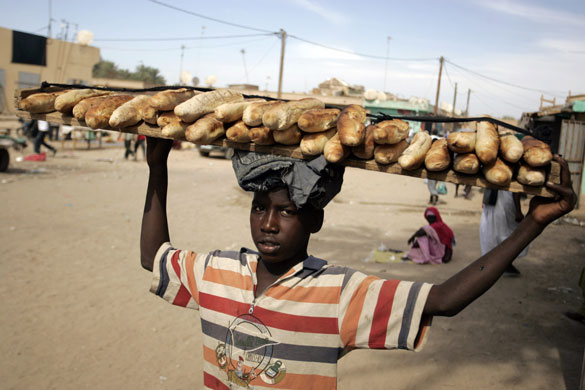 24 hours: Nouakchott, Mauritania: A boy carries loaves of bread at the market