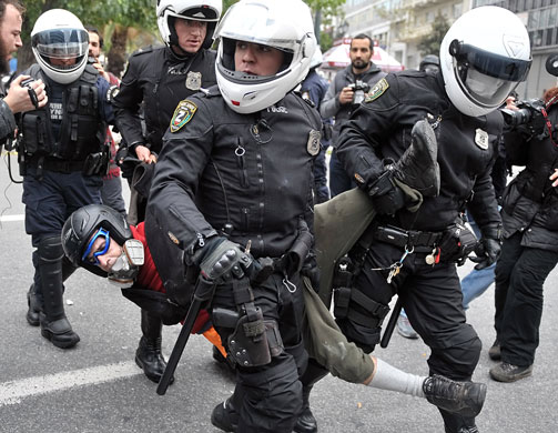 Athens demonstrations: Police carries a detained demonstrator in central Athens