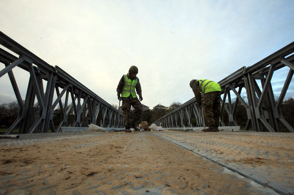 Workington: Soldiers construct a foot bridge across the river Derwent