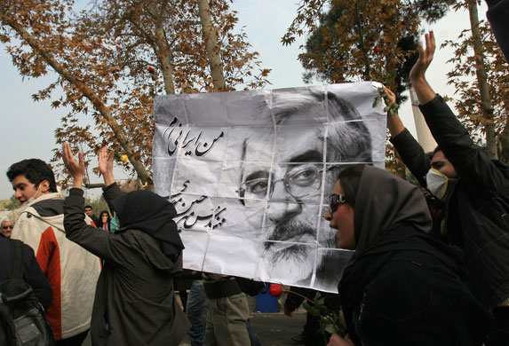 Tehran protests: Iranian opposition supporters hold a picture of Mir Hossein Mousavi 