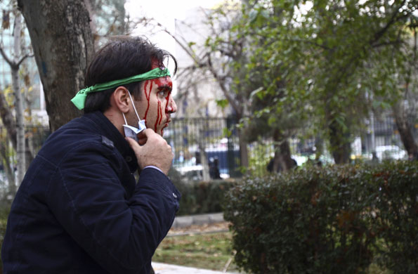 Tehran protests: A pro-reform Iranian student beaten by hard-liners at a demonstration