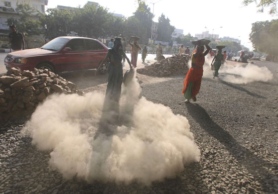 24 hours in pictures: Women labourers work at a road construction site in Ahmedabad