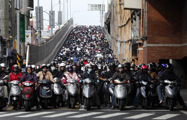 24 hours in pictures: Motorists ride to work on a bridge during rush hour in Taipei, Taiwan