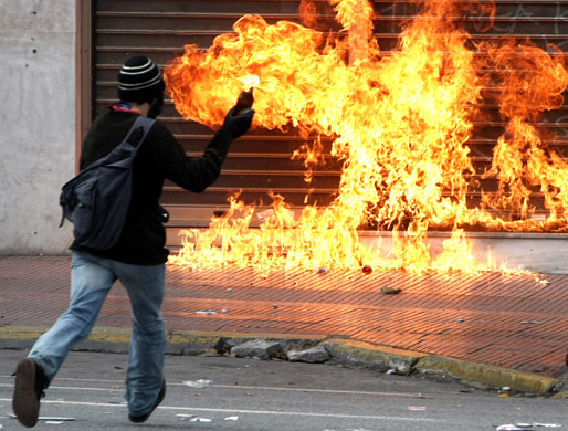 more voilence in athens : A protester prepares to throw a petrol bomb inAthens
