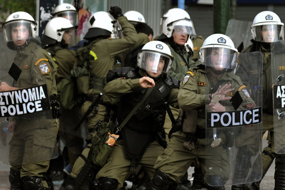 more voilence in athens : Riot police members protect themselves from stones  