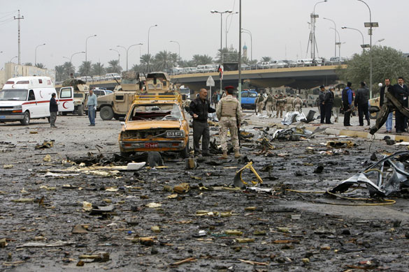 Baghdad bomb attacks: Iraqi security personnel are pictured at the site of a bomb attack