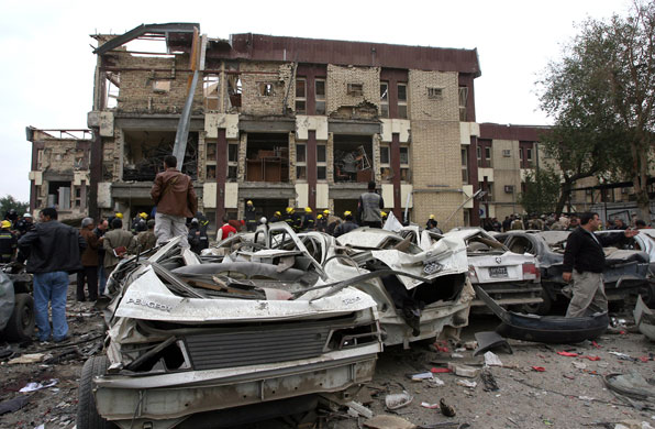 Baghdad bomb attacks: Iraqis gather near destroyed cars outside a criminal court building