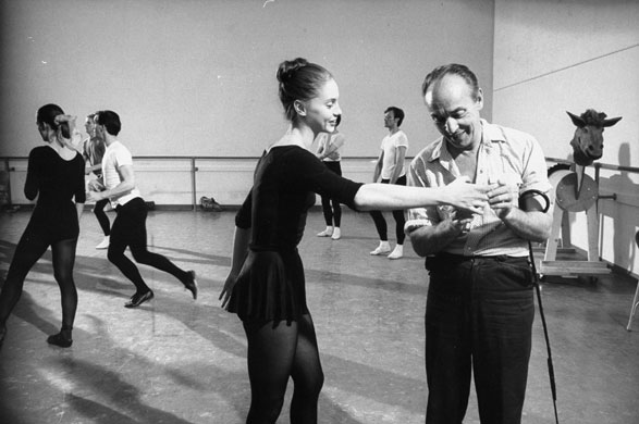 Ballets Russes: George Balanchine examining hand of dancer Suzanne Farrell