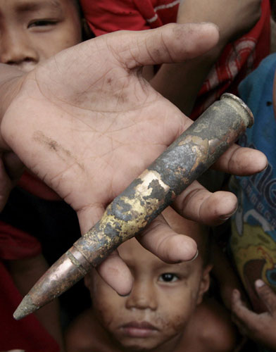 Gallery 24 hours in pictures: A Filipino boy holds a bullet in Manila, Philippines,