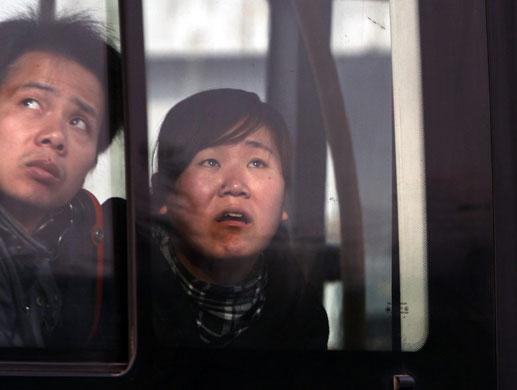 Beijing fire: People on a bus look at the fire damage as they pass the Mandarin Oriental