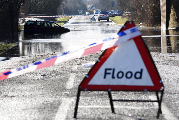 Bad weather: An abandoned car is partially submerged in flood water on a road in Bledlow