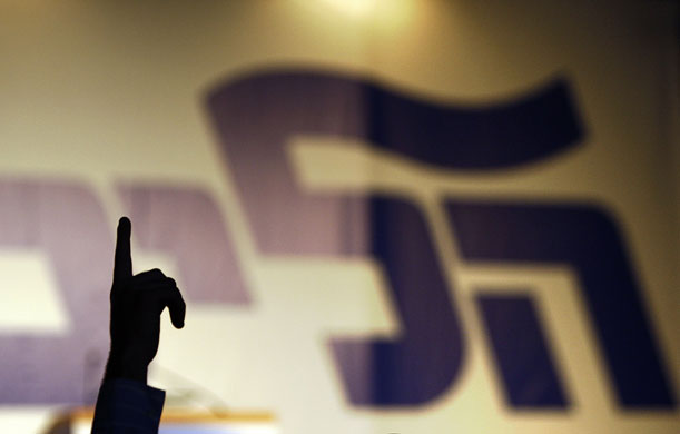 Elections in Israel: A supporter of the Likud party gestures in front of a party poster