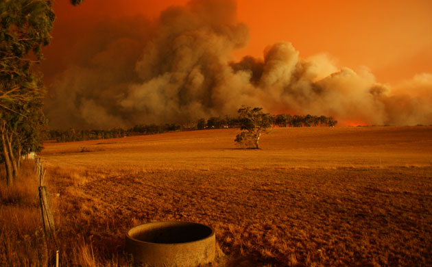 Landscape turns orange and smoke fills the sky during a blaze in Churchill, Victoria, 09 Feb 2009. Photograph: Rhys Smith / Newspix / Rex Features